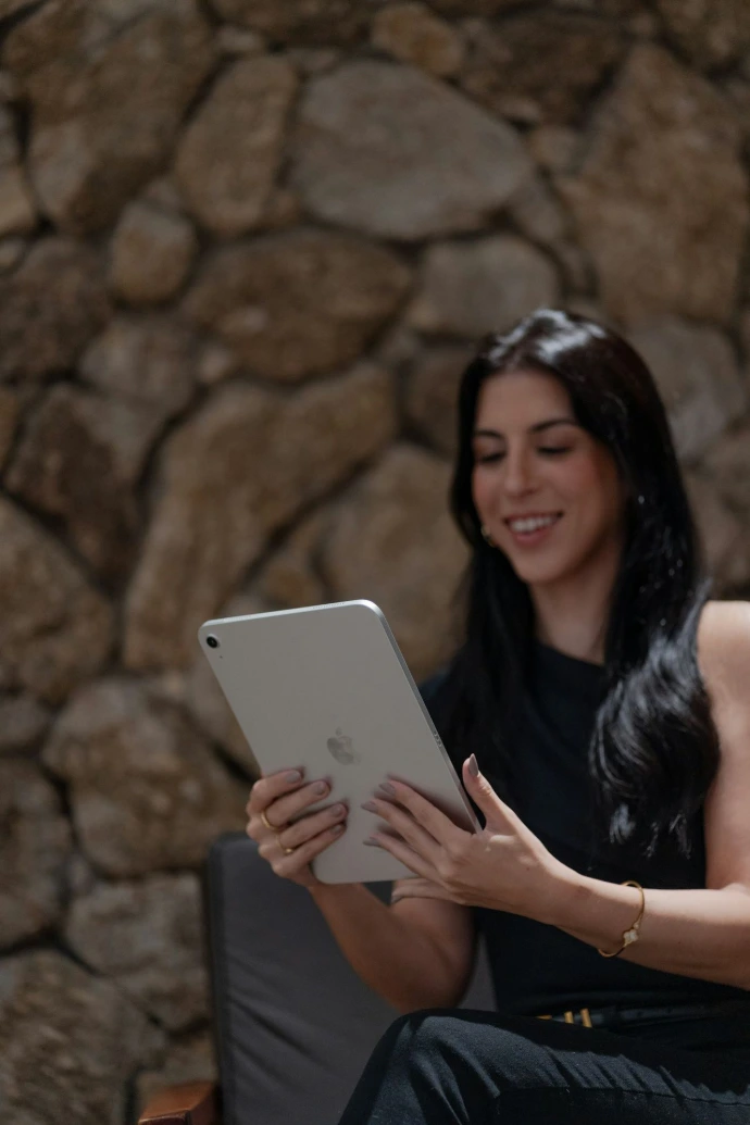 A woman sitting on a chair using a tablet